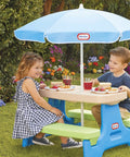 Children at Six Seat Kids Picnic Table With Umbrella Multi Color Outdoor Play Table with snacks in a garden setting