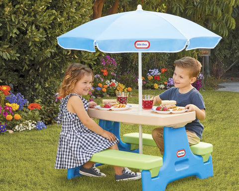 Children at Six Seat Kids Picnic Table With Umbrella Multi Color Outdoor Play Table with snacks in a garden setting