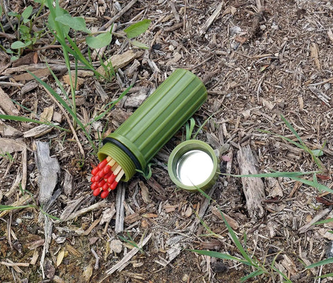 3 In 1 Green Waterproof Match Storage Box With Signaling Mirror And Firestarter Flint open in grass