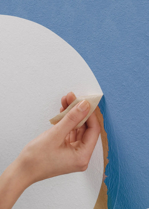 Hand applying Masking Tape For Curves Ultra Flexible 19mm by 25m Pro Grade Tape on blue curved surface