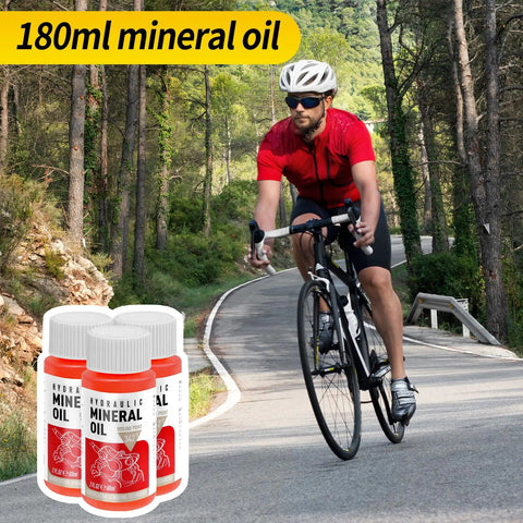 Cyclist on road with All In One Pro Grade Hydraulic Brake Bleed Kit With 180ml Mineral Oil bottles in foreground