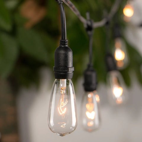 Close-up of lit 24 Pack Edison Style Replacement Bulbs For Outdoor String Lights 7W E17 ST40 Clear Glass Lamps Warm White 2300K