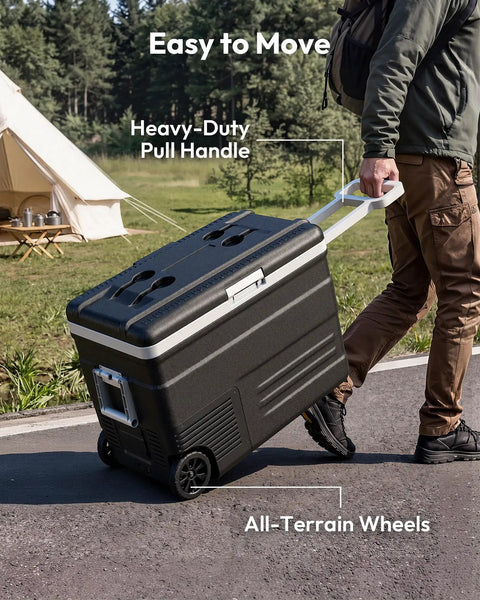 Person pulling a Smart 12V Car Fridge 59 Quarts With App Control And LCD Panel on all-terrain wheels in a camping setting.