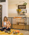 Decorative Walk-Thru Baby And Pet Gate For Openings Up To 60 Inches, 30 Inch Tall with walnut wood and charcoal metal in living room