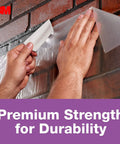 Applying No Residue Duct Tape 1.88 Inch By 20 Yards Grey 2420A Heavy Duty Adhesive for quick fixes on a brick wall