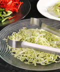 Restaurant Grade 6.5 Inch Pom Tong Set Of 6 Stainless Steel Garnish Tongs with satin finish resting on shredded cabbage dish.