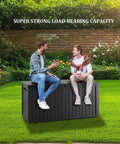 Two people sitting on a 200 Gallon Waterproof Outdoor Storage Box Built Tough Resin Deck Box in a garden