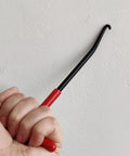 Side view of a red-handle rubber-coated motorcycle exhaust spring hook tool with a curved hooked end