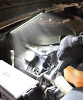 Mechanic using Rechargeable LED Slim Work Light 450 Lumen With XL Battery Magnetic Swivel Base under vehicle hood.