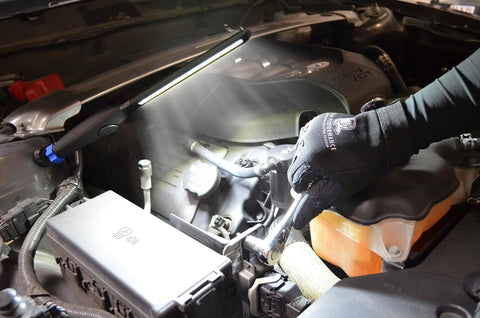 Mechanic using Rechargeable LED Slim Work Light 450 Lumen With XL Battery Magnetic Swivel Base under vehicle hood.