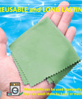 Green microfiber cleaning cloths held in a hand; reusable for cleaning screens and eyewear.