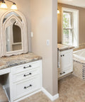 Elegant bathroom with white cabinets, marble countertop, and decorative mirror; potential location for electronic countdown timer switch.