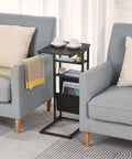 C Shaped End Table With Three Tiers And Storage Bag Easily Slides Under Sofa Or Bed Space Saving Couch Table displayed between armchairs.