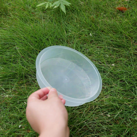 Person holding one of Two Pack Plastic Round Bird Feeder Bowls For Wild Birds Seed Tray And Water Bowl At Feeding Stations Easy To Clean Clear Water Visibility Attract Birds on grass
