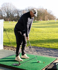 Person using Unisex Base Unit For Golf Swing Training Black on driving range to improve swing plane and weight transfer