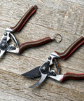 Elite Pruning Shears 8.3 Inch Swiss Made Garden Clippers with leather wrapped handle and carbon steel blades on wood surface