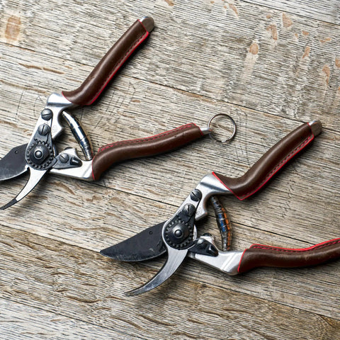Elite Pruning Shears 8.3 Inch Swiss Made Garden Clippers with leather wrapped handle and carbon steel blades on wood surface