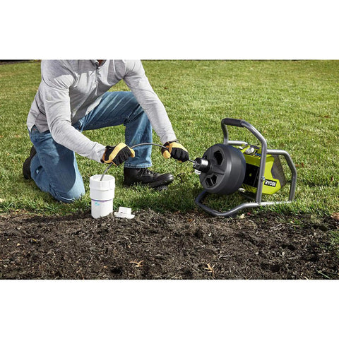 Powerful 18V Cordless Drain Auger Kit With 50 Ft Reel, 2Ah Battery, Charger, Pivoting Drum And Rubber Foot Pad in use outdoors.