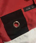 Close-up of red and white Freediving Pro-Grade Buoy With Inner Tube And 8 Inch Dive Flag Cover showing zippered compartment and grommet.