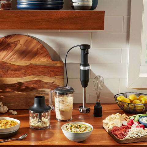Heavy Duty Variable Speed Corded Hand Blender With Removable Pan Guard And Sharp Stainless Blades for smooth soups on wooden table.