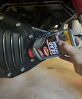 Top Tier Axle And Differential Gear Repair Fluid being poured into gear casing for automotive use.