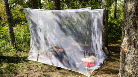 Rectangular Mosquito Net For Camping And Outdoors Lightweight Mesh Canopy installed over sleeping bag in forest setting