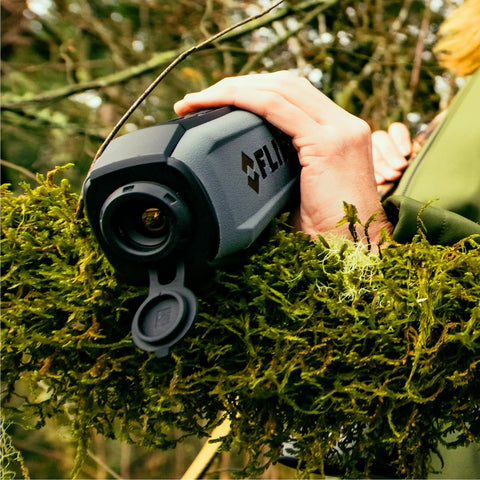 Person holding Scion OTM 9Hz Thermal Imaging Monocular With Onboard Video Recording And MicroSD Expansion in forest setting
