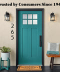 Home entryway with teal door, welcome mat, plants, and decorative pillows showcasing inviting atmosphere.