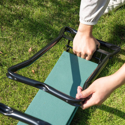 Hands folding a Thick Padded Garden Kneeler And Seat Bench For Easy Weeding Foldable Garden Stool on grass