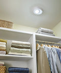 Motion Activated LED Ceiling Lampholder 8.7W 120VAC 9864-LED in closet, illuminating shelves with clothes.