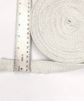 Lynn Manufacturing high-temperature flat gasket tape, white, 1in x 1/8in x 25ft, coiled roll beside ruler