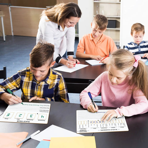 Children in a classroom using the Double Sided Place Value Board 9x12 Inches For Kids, Dry Erase Math Manipulative To Teach Place Values From Billions To Decimal Numbers, A Kid Friendly Lapboard For Home School And Classroom.