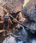 Hikers with backpacks crossing rocky stream, using Heavy Duty Nylon Pack Liner Bags 20 By 36 Inch 10 Pack Thick Five Point Five Mil Clear Liners.