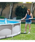 Woman using the Deluxe Above Ground Pool Maintenance Kit With Vacuum For 800 GPH Flow Rate 110 Inch Telescoping Pole Wall Brush And 24 Foot Hose Color May Vary So You Can Clean Like A Pro No Hassle on a summer day.