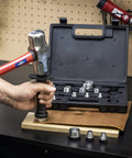 Person using the 14 Piece Hollow Hole Punch Kit For Gaskets, Leather And Foam, SAE And Metric Sizes, tool in carrying case on workbench.