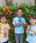 Kids wearing Kids Blue Safety Glasses Lightweight Protective Eyewear For School And Lab Use, holding colorful toys outdoors.