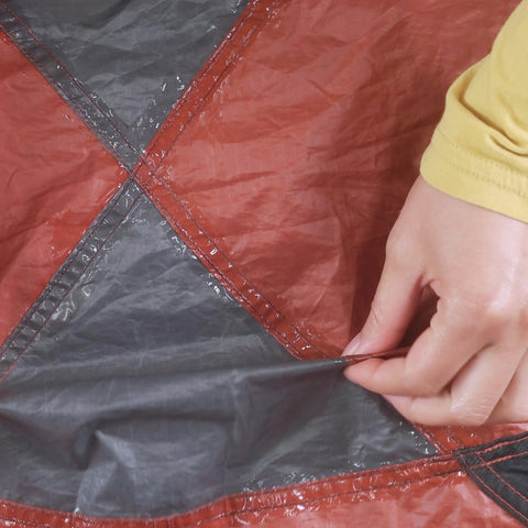 Applying Seam Grip WP Waterproof Sealant And Adhesive For Jackets Tents Tarps Rain Gear And Outdoor Fabric on a tarp seam