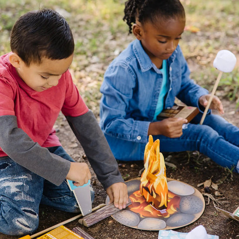 Kids playing with Campfire S'mores Pretend Play Set With 23-Piece Toy Food Kit For Kids 3 Plus, including logs and marshmallows.