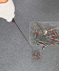 Hand using telescoping magnetic pickup tool with 20 lb pull strength, extends from 7 to 31 inches, picking up screws on carpet
