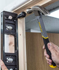 All-In-One Adjustable Door Hinge Jig Installation Kit For 2 Ft 6 In To 9 Ft Doors being used on a door frame with a hammer by Trend