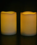 Waterproof Outdoor LED Flameless Candles with Remote, 3x4 inches, white plastic pillars with warm flicker, shown in dim lighting.