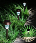 Bronze Solar Path Light Set Of 6 With Glass Lens And Metal Ground Stakes Plus Super Bright LED illuminating a garden path at night