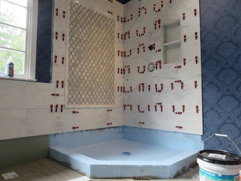 Bathroom wall with tiles installed using One Eighth Inch T Lock Tile Leveling Kit With 300 Spacers And 100 Wedges In Handy Bucket.
