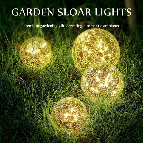 Solar Globe Lights 6 Inch Outdoor Crackled Glass Orbs glowing warm yellow in grass for patio yard backyard decor, set of four