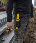 Worker wearing Magnetic Level With Holster 81S10MH For Steel Erectors And Scaffolders attached to belt on construction site.