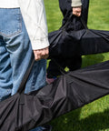 People carrying carrying bags for Heavy Duty Outdoor Hammock With Collapsible Steel Stand And Carrying Case, On The Go And Adjustable.