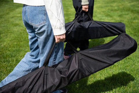 People carrying carrying bags for Heavy Duty Outdoor Hammock With Collapsible Steel Stand And Carrying Case, On The Go And Adjustable.