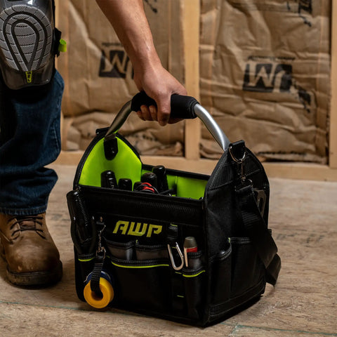Person carrying 12 Inch Pro Tool Tote With Rotating Handle For Easy Access, Water Resistant Construction, Black, Durable Tool Bag With Large Compartments On Jobsite