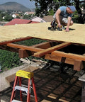 Man installing Natural Bamboo Fence Roll Panel 0.75 Inch Thick 6 Foot High By 8 Foot Long on a wooden pergola.