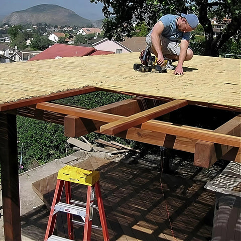 Man installing Natural Bamboo Fence Roll Panel 0.75 Inch Thick 6 Foot High By 8 Foot Long on a wooden pergola.